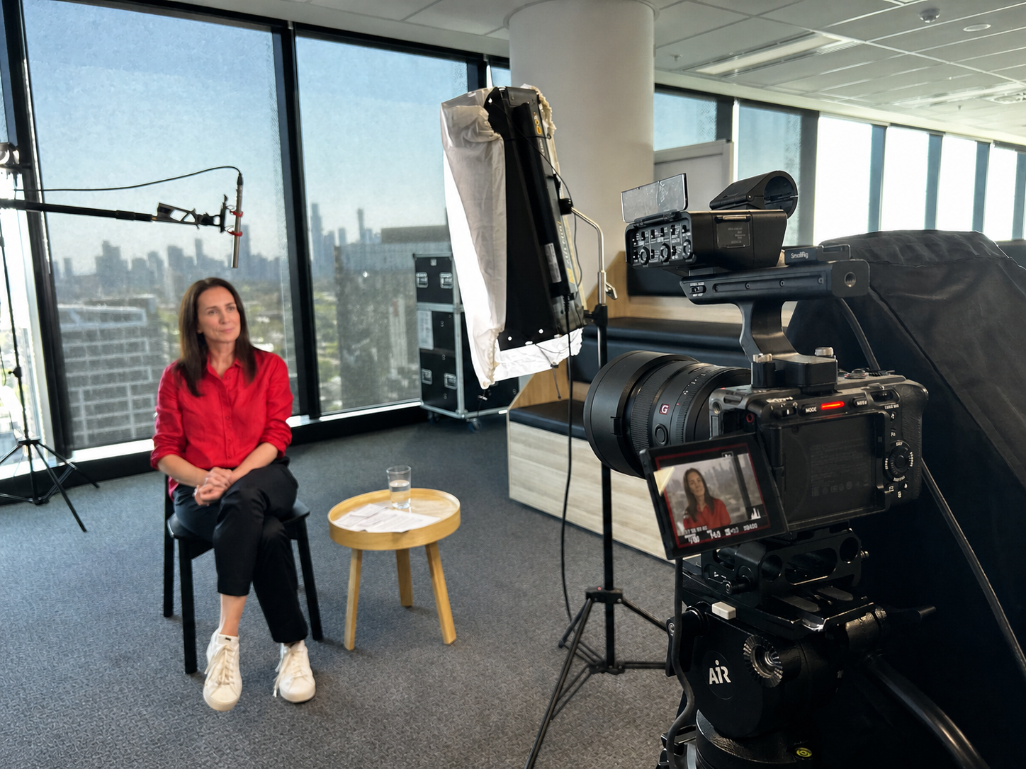 Melbourne camera crew filming a corporate interview with the city skyline in the background