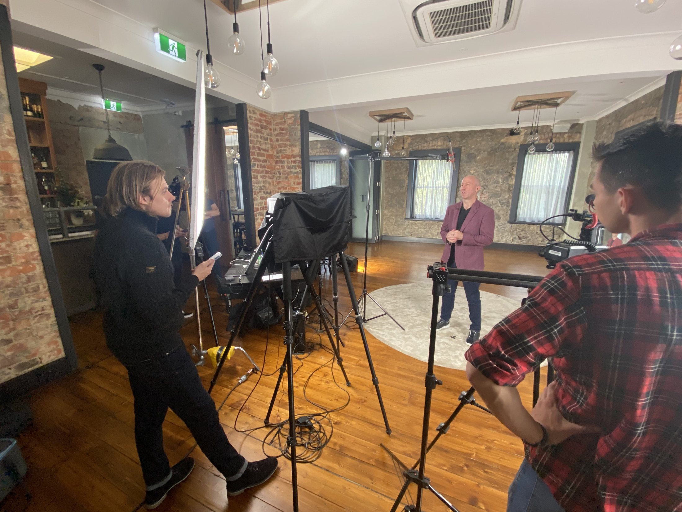 Presenter and production crew working around the camera and lighting setup